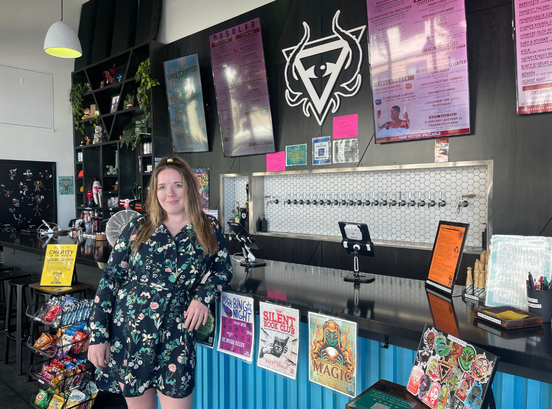 Ansley standing in front of bar with DSSOLVR logo in the background